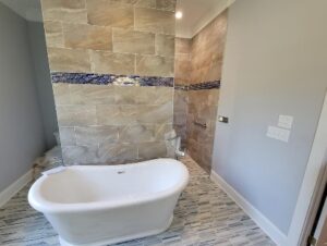 Remodeled bathroom with freestanding tub and tile wall